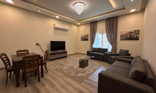 Luxury Apartment in the Saar Area with a modern living room, dining area, sectional sofa, tv console, and decorative lighting, fully-furnished.