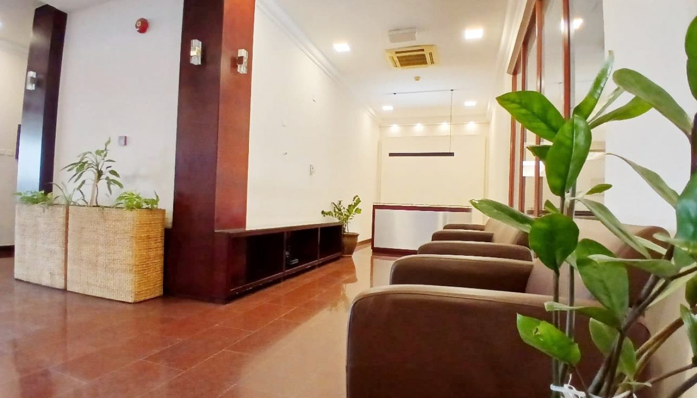 A modern waiting area with brown sofas, potted plants, and tiled flooring features an Auto Draft system.