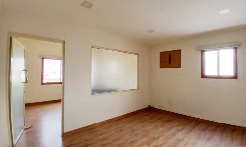 Empty commercial flat in a prime location in Guful, with hardwood floors, a large mirror, and a window.