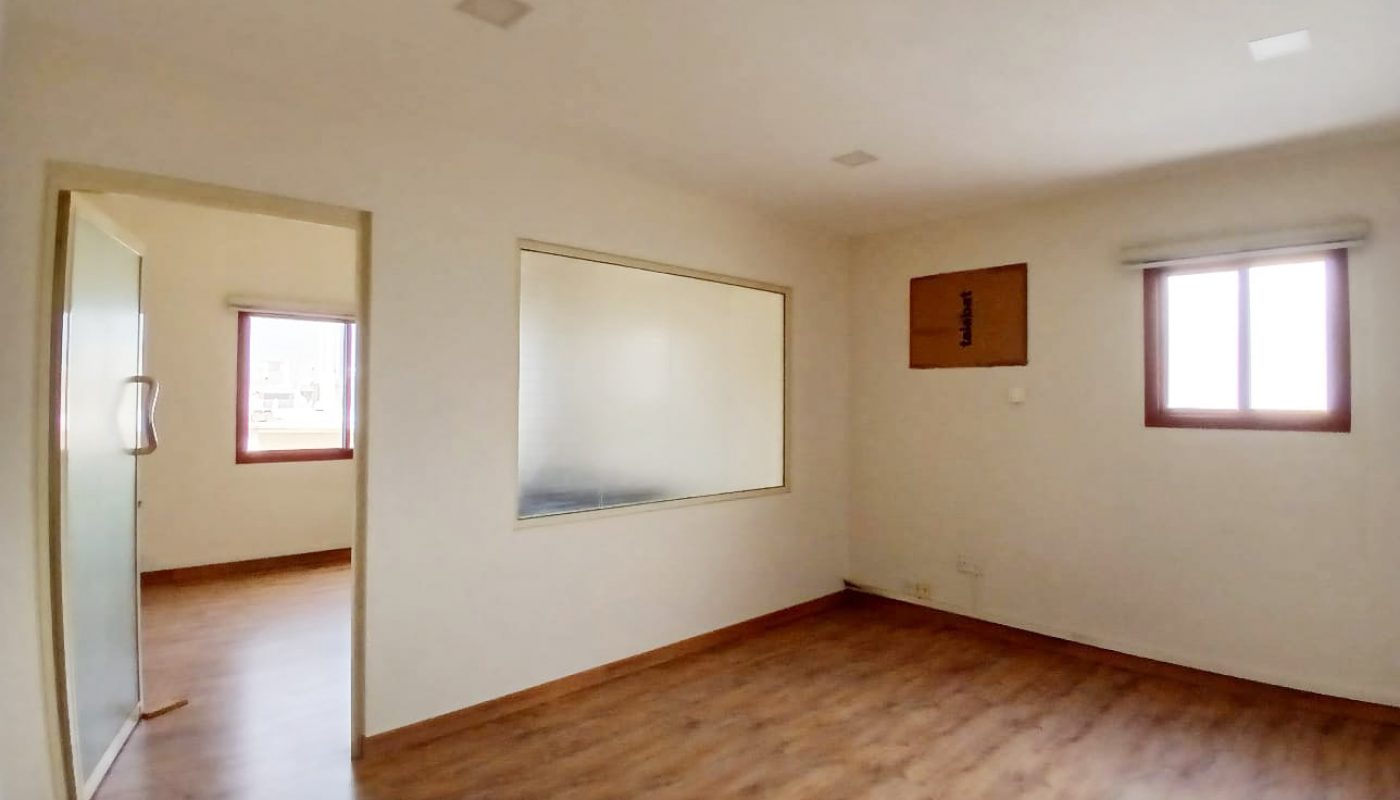 Empty commercial flat in a prime location in Guful, with hardwood floors, a large mirror, and a window.