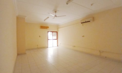 Empty commercial flat in Guful with white tiled flooring, cream walls, a ceiling fan, and an air conditioning unit in a prime location.