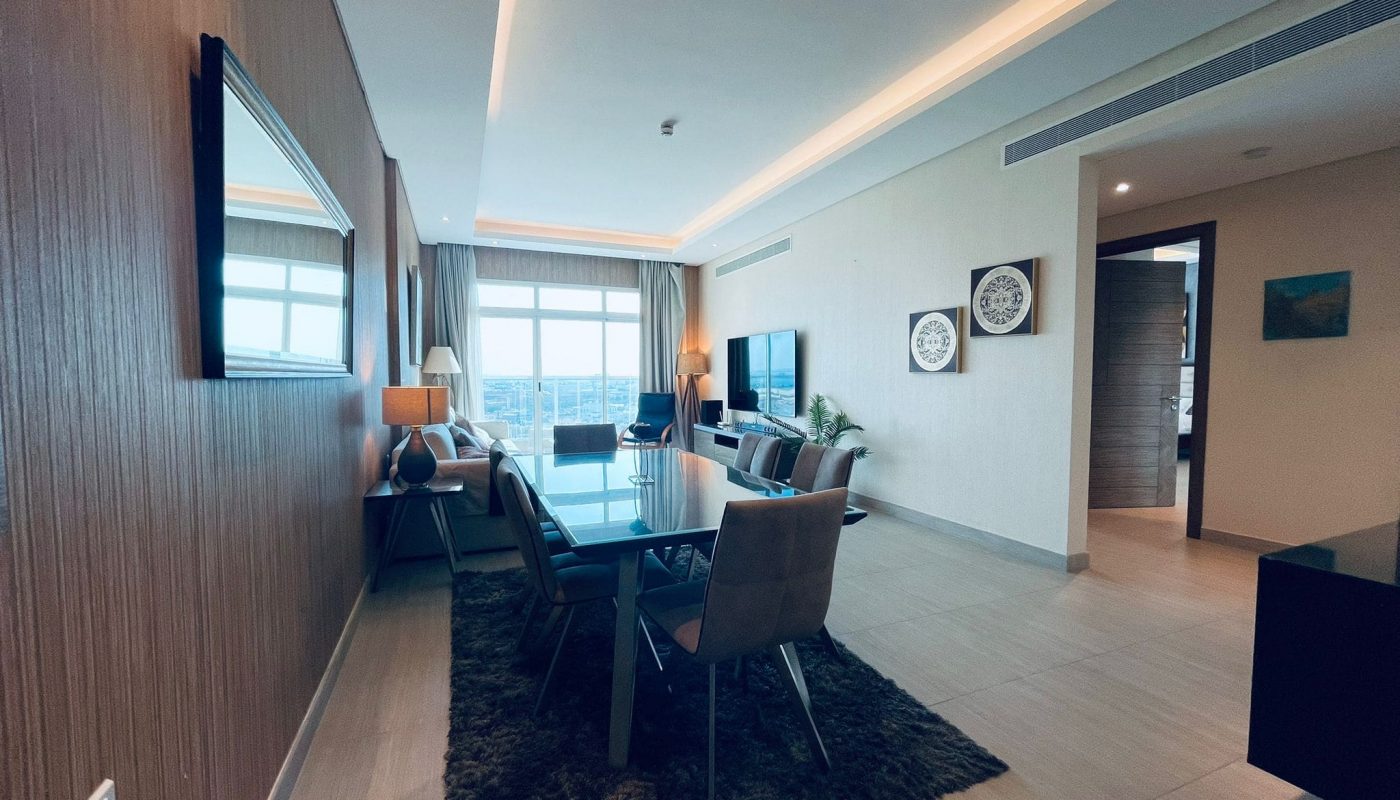 Modern apartment interior with an open-plan living and dining area, featuring contemporary furniture, large windows, and wooden floors.