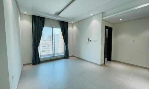 Apartment for rent: Modern interior with white walls, large window with dark curtains, and tiled flooring.