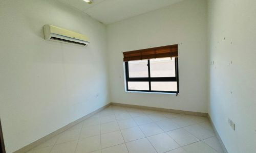 Empty room with white walls, a tile floor, a window with a wooden blind, and an air conditioning unit mounted on the wall.