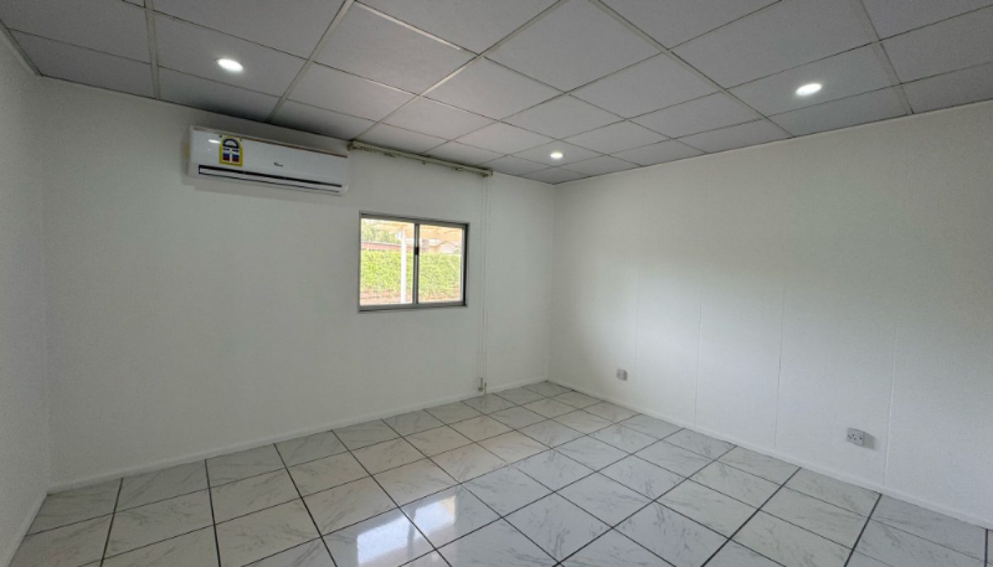 Empty room with white tiled floor, white walls, a small window, ceiling lights, and a wall-mounted air conditioner.