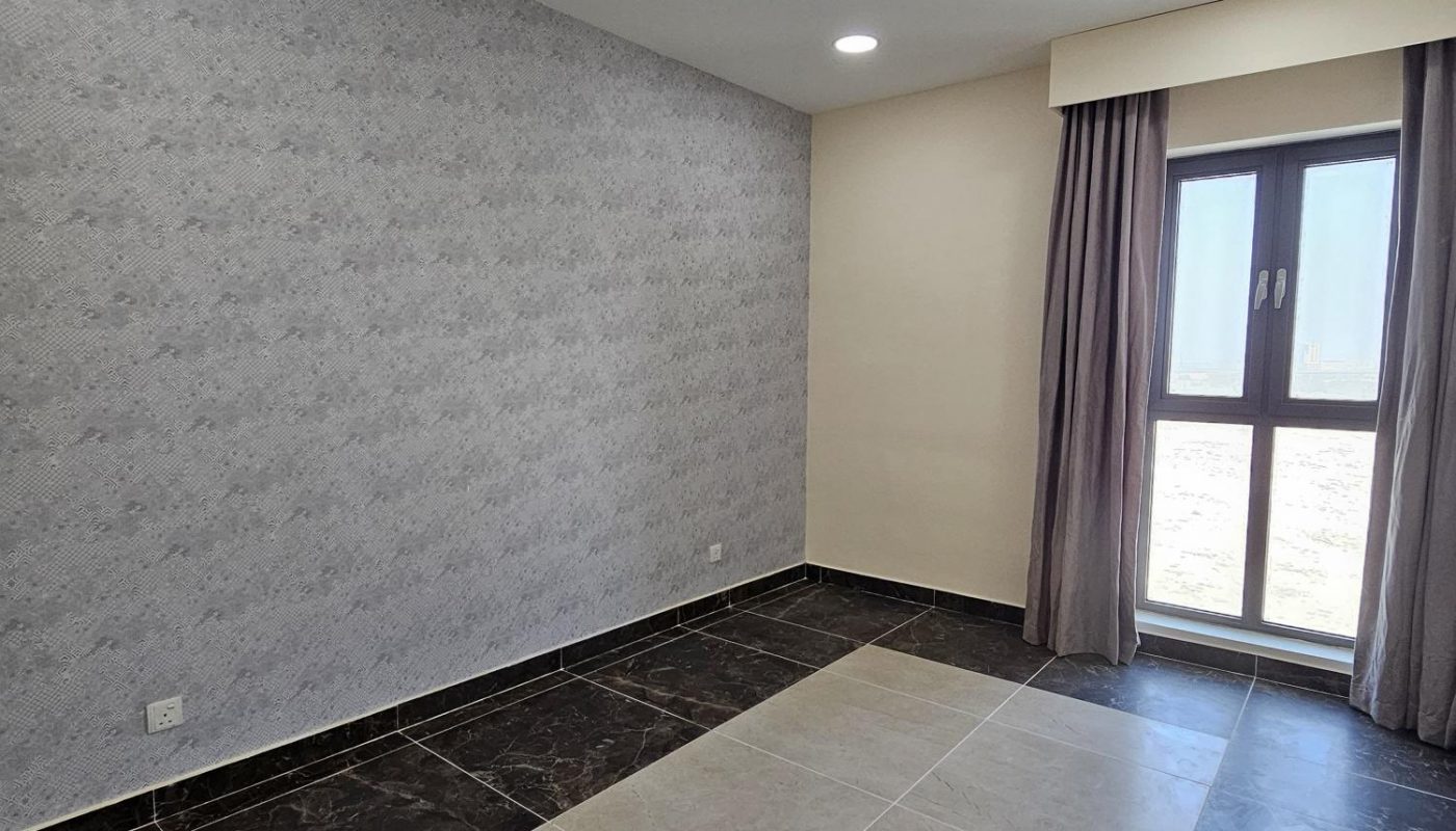 Unfurnished room with patterned wallpaper, tiled floor, ceiling lights, and a window with curtains allowing natural light inside.