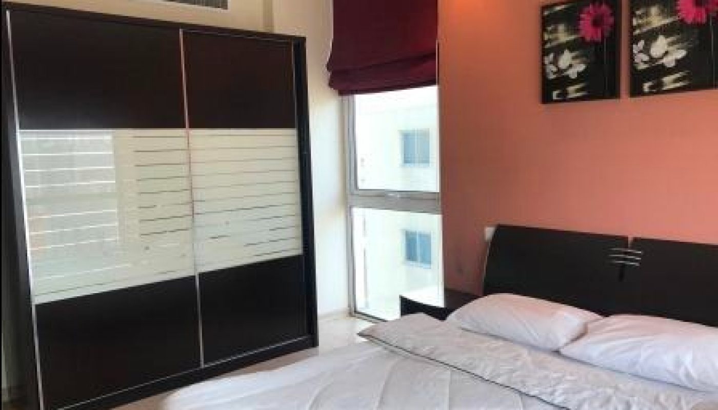 A modern bedroom with a double bed, headboard, two pillows, a wardrobe with sliding doors, a window, and two floral artworks on a peach-colored wall.