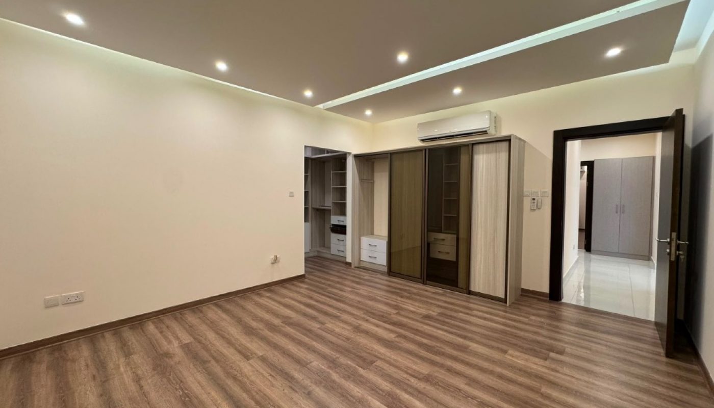 Unfurnished room with wood flooring, built-in wardrobes, air conditioner, recessed lighting, and an open doorway leading to another area.