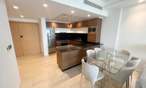 A luxury kitchen and dining area in a delmunia-modern apartment.