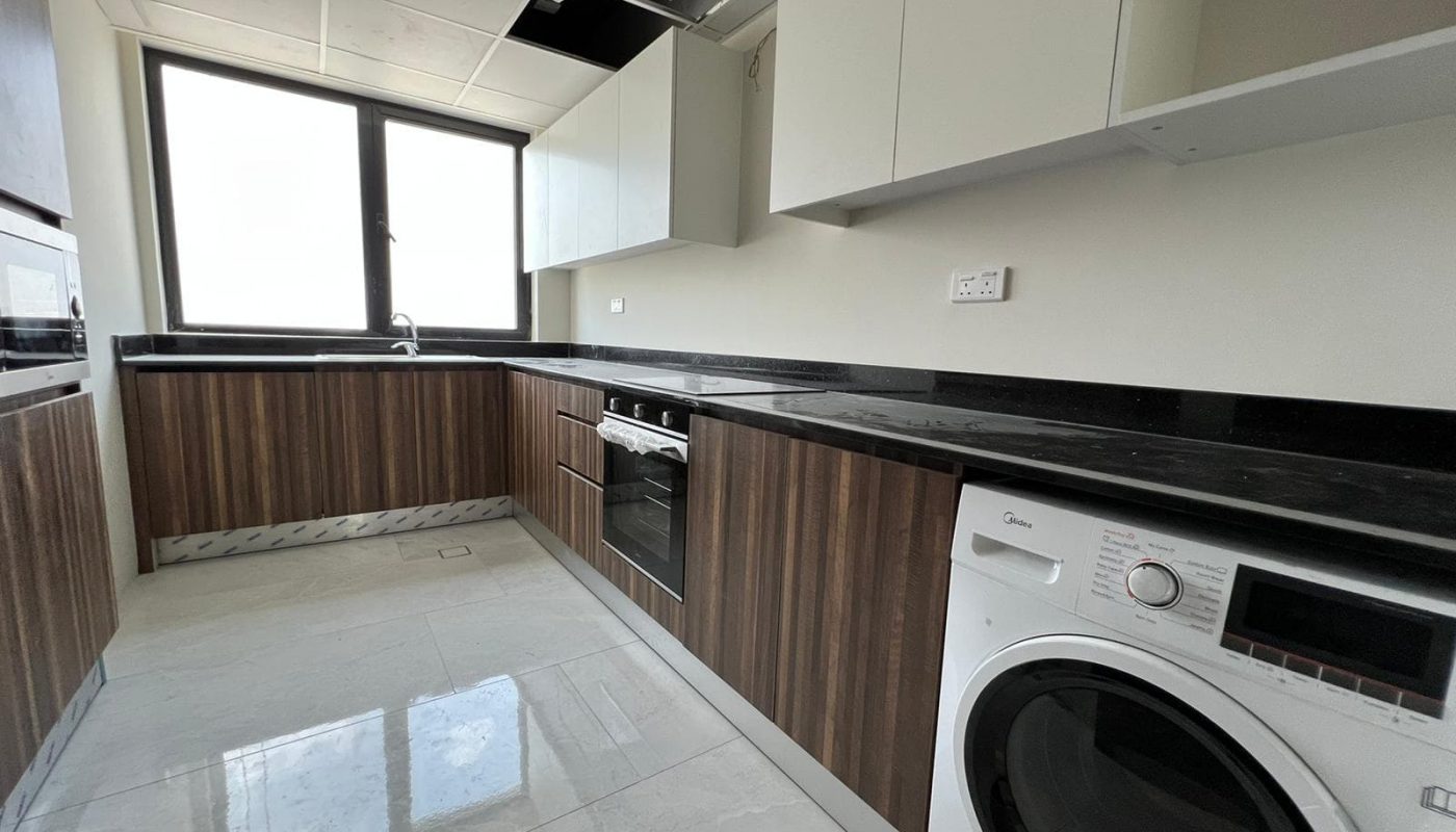 Stunning 2BR Apartment for Sale in Amwaj Island featuring a kitchen with a washer and dryer.