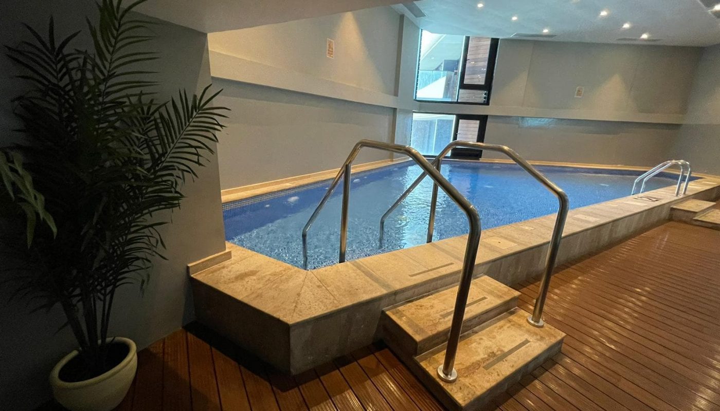 An indoor swimming pool in a room with wooden floors, located in the FF Apartment on Dilmunia Island.