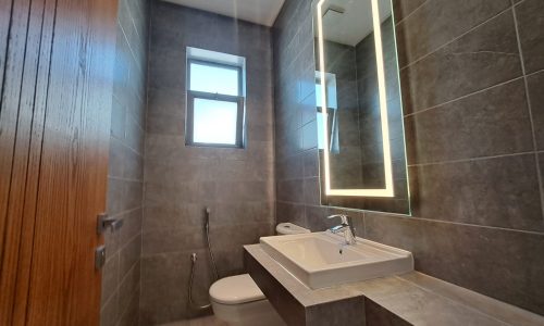 A modern bathroom with a toilet and sink in a luxury apartment in al Janabiya.