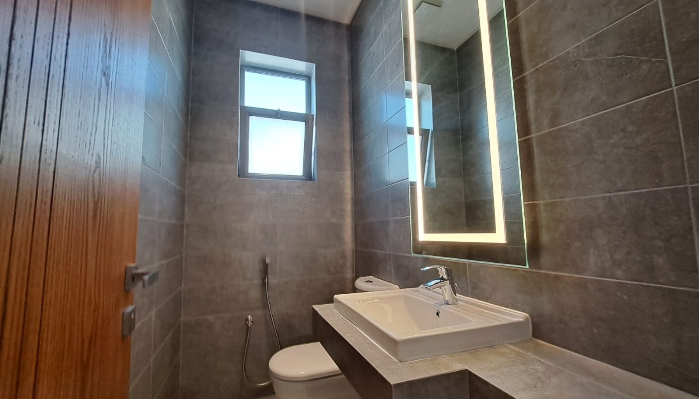 A modern bathroom with a toilet and sink in a luxury apartment in al Janabiya.