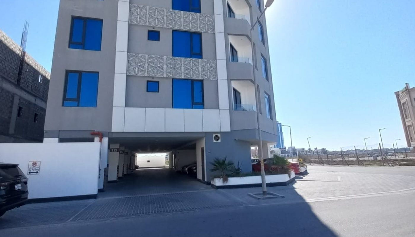 A Seef apartment building with a car parked in front of it.