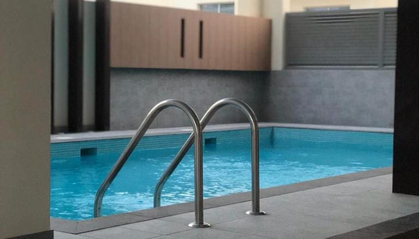 A luxurious apartment with a swimming pool in the middle of the building, available for sale in Busaiteen.