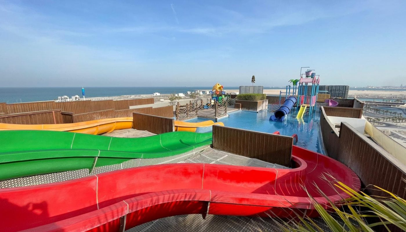 An elegant water park with colorful slides and a view of the ocean for sale.
