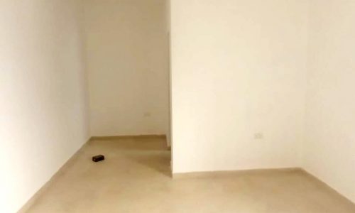 A vacant villa in Bani Jamra with white walls and a door, available for sale.