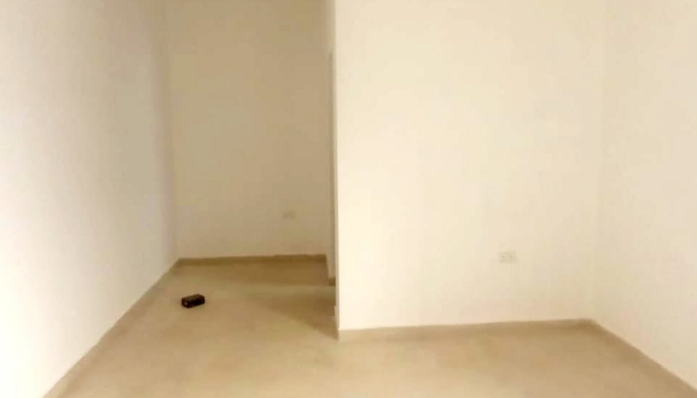 A vacant villa in Bani Jamra with white walls and a door, available for sale.