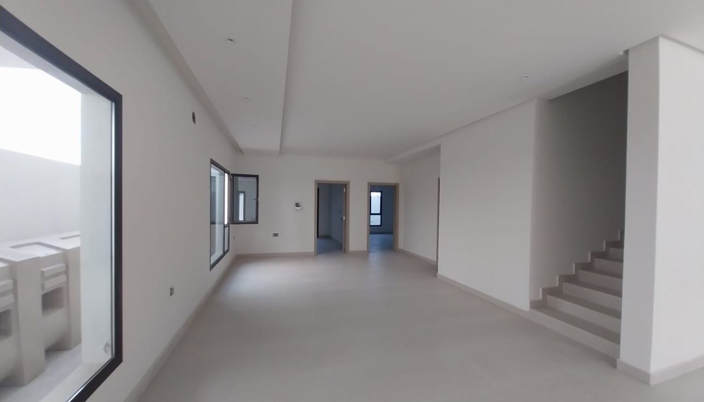 A white room with stairs and windows.