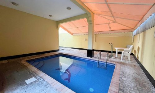 An outdoor pool area featuring a table and chairs.