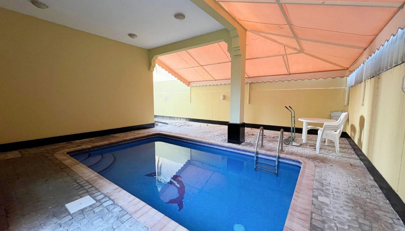 An outdoor pool area featuring a table and chairs.