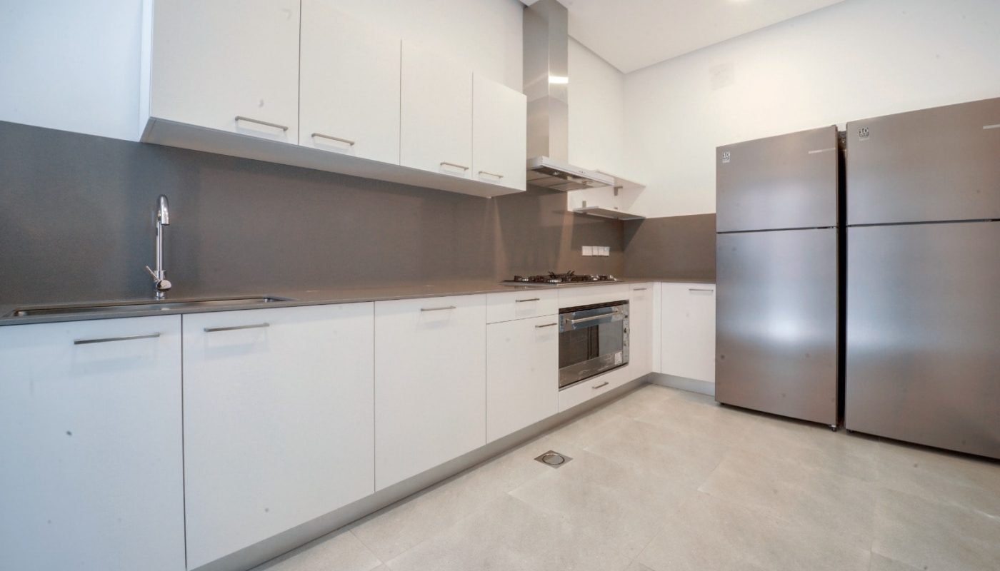 An opulent villa with a kitchen featuring stainless steel appliances and white cabinets.