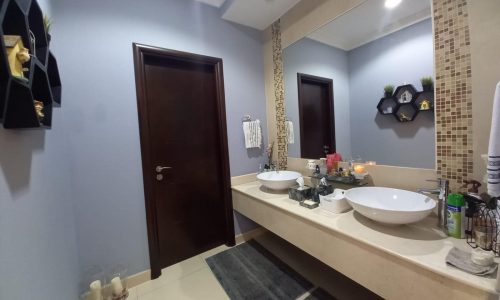 A spacious bathroom with two sinks and a mirror.