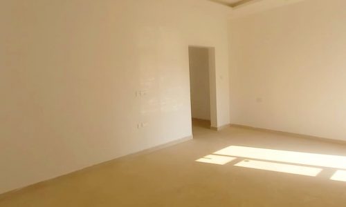 A Bani Jamra villa for sale, featuring an empty room with white walls and a window.