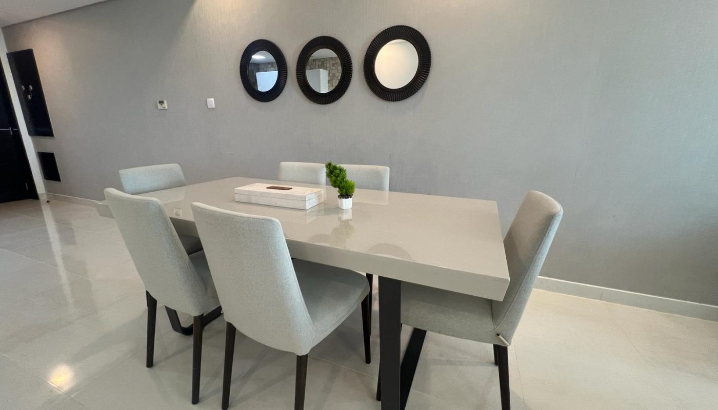 A dining room with a white table and chairs.