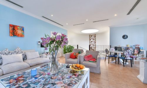 A stunning living room with blue walls and white furniture.