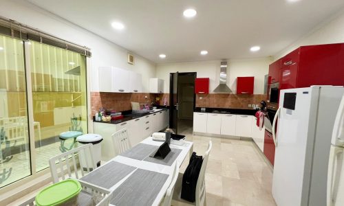 A kitchen with red and white cabinets and a table. Red cabinets are a bold choice for any kitchen, instantly adding a vibrant and energetic atmosphere. Paired with the sleekness of the white