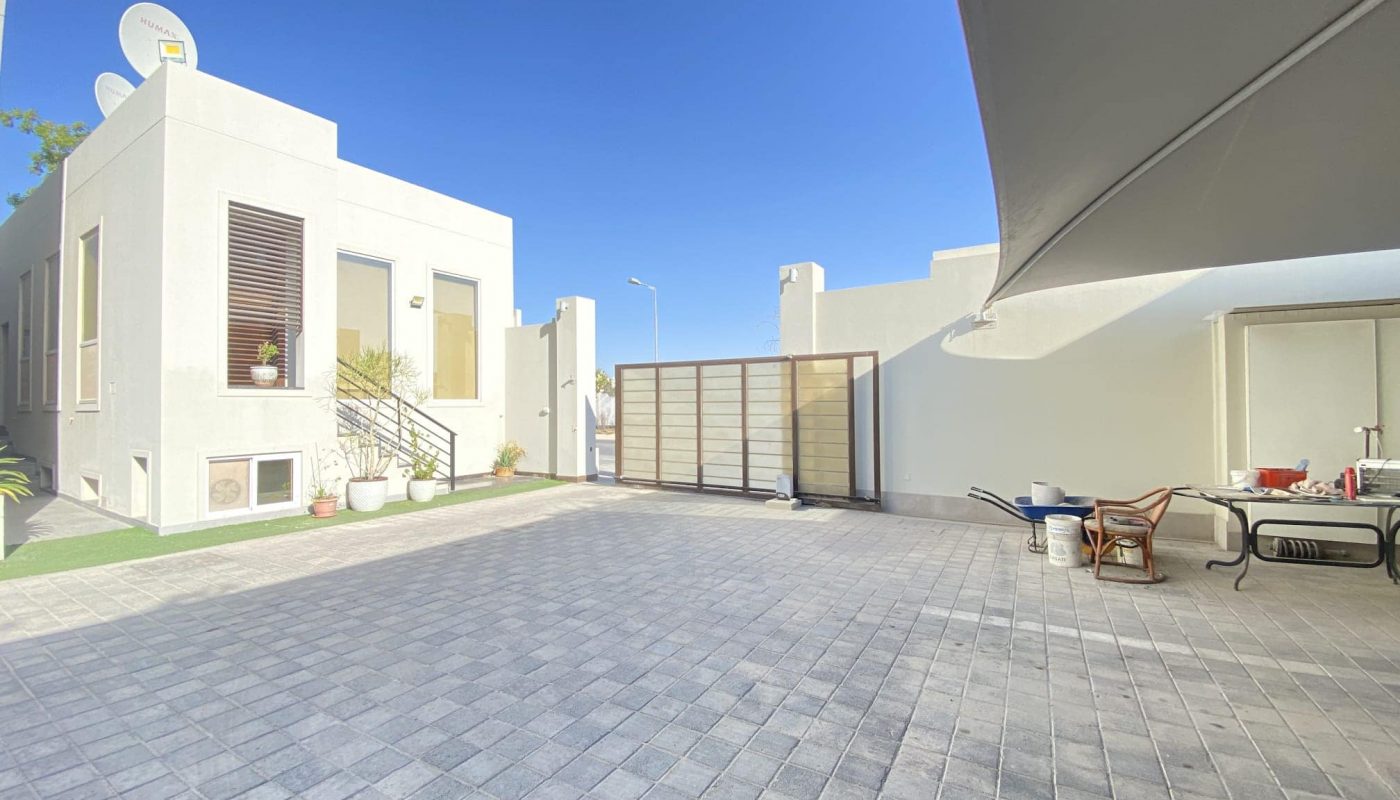 A courtyard with a table and chairs in front of a residential compound in Al Janabiyah.