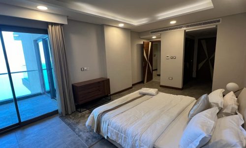 A luxury bedroom with a large bed and sliding glass doors.