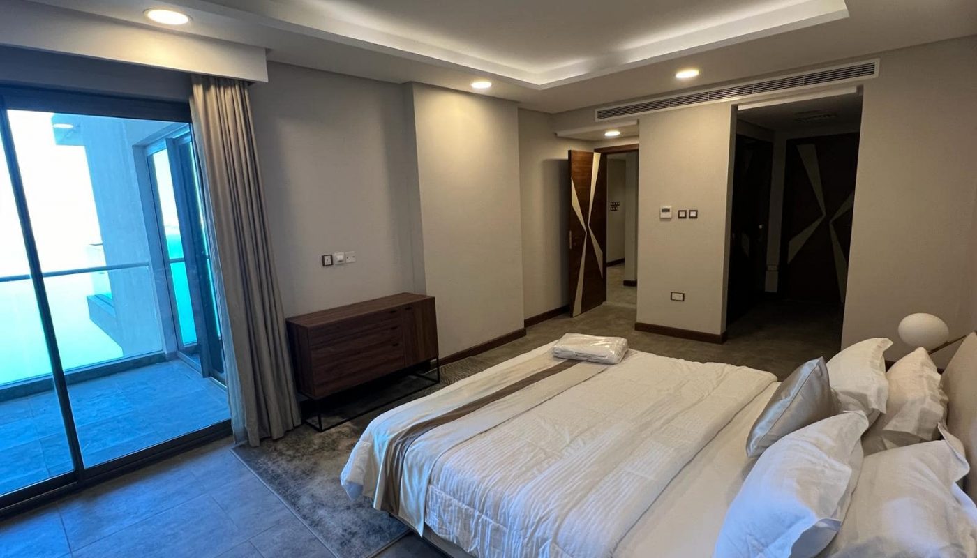 A luxury bedroom with a large bed and sliding glass doors.