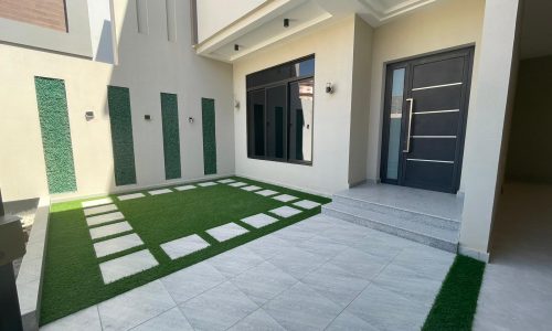 Bright green lawn with modern house for sale.