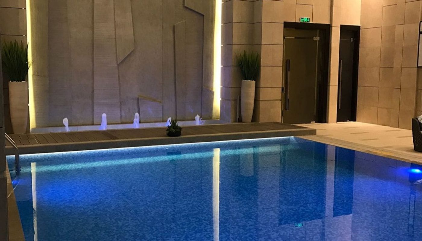 An indoor swimming pool in a modern building with sea view.