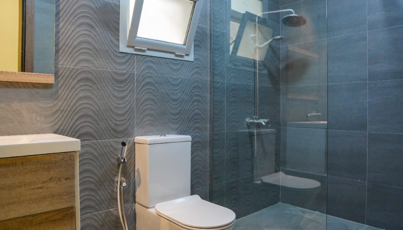 A modern bathroom with a glass shower and toilet located in a great location.