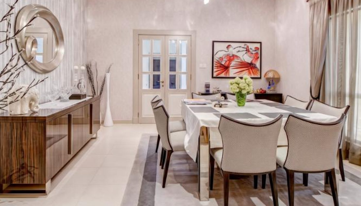 Modern dining room with a rectangular table set for six, a sideboard with a round mirror, framed art on the wall, and neutral-toned decor accents.