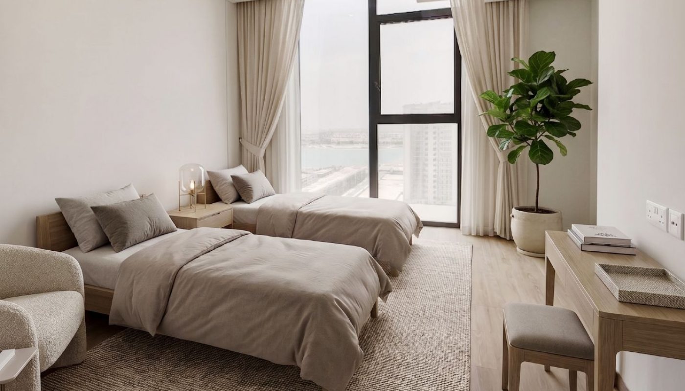 A modern bedroom with two single beds, a desk with a chair, a potted plant, large windows with city and water views, and neutral-colored decor.
