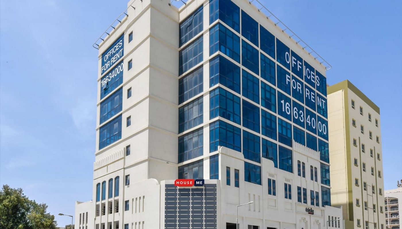 This exclusive modern multi-story office building with large windows boasts prominent "Offices for Rent" signage. Surrounded by other structures and lush vegetation, it offers a prime location for businesses seeking to maximize ROI on their investment.