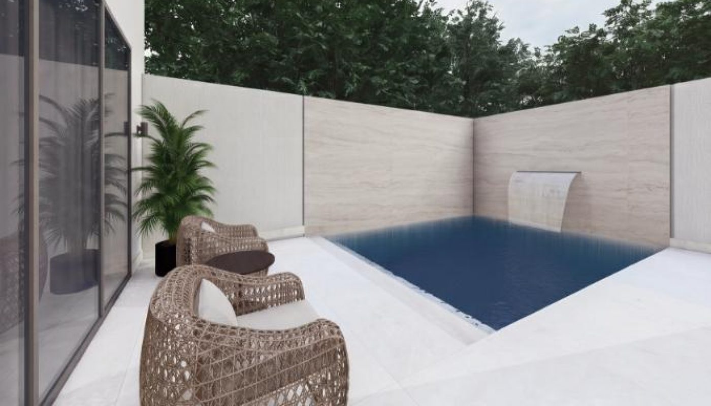 Outdoor patio with two wicker chairs facing a small rectangular pool, surrounded by light-colored walls and greenery in the background.