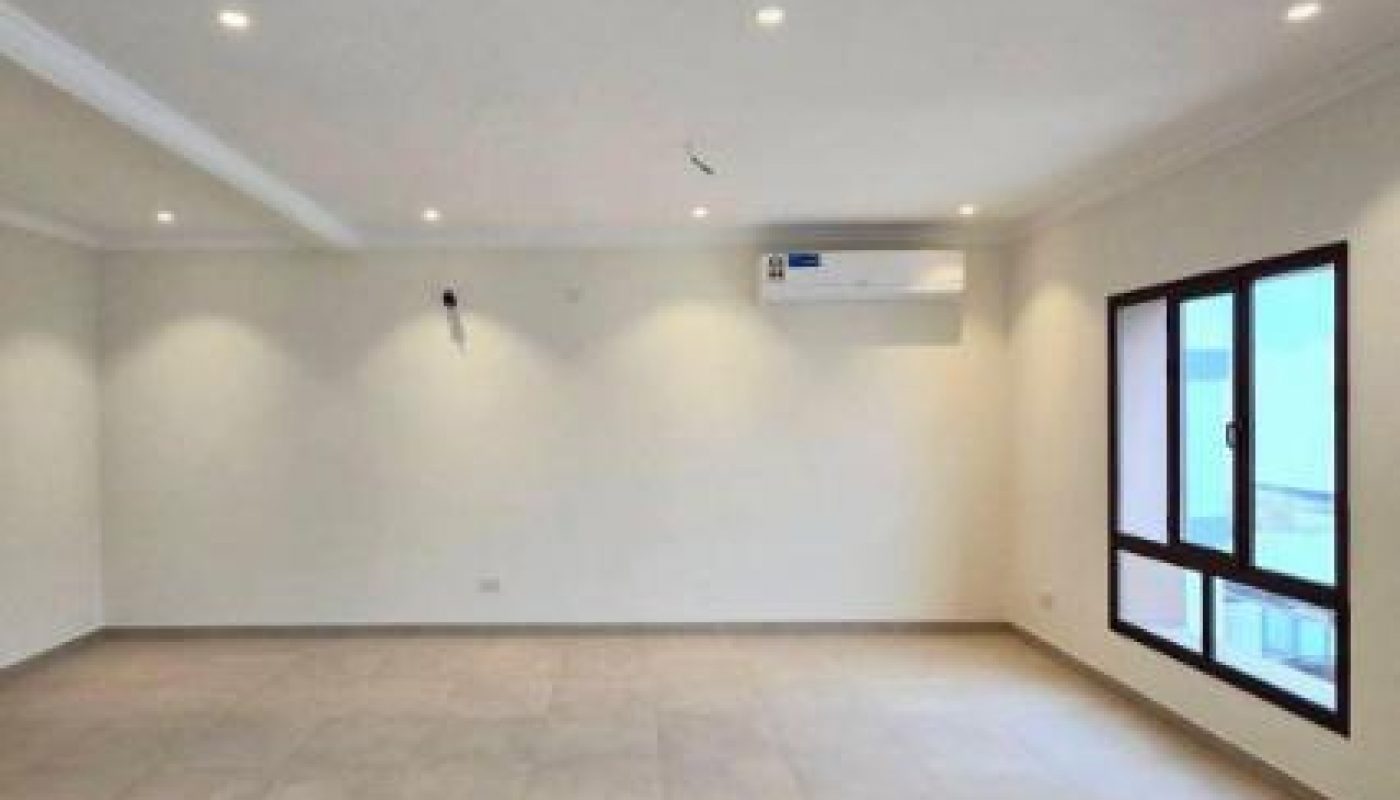 Spacious, empty room with tiled floor, white walls, recessed lighting, a large window, and a wall-mounted air conditioner.