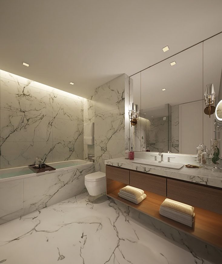 Modern bathroom with marble floors and walls, a bathtub, toilet, large mirror, and dual-sink vanity with wooden shelves and folded towels.